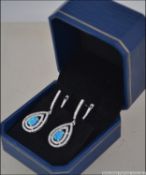 A pair of silver and blue opal drop earrings adorned with cz stone surrounds.