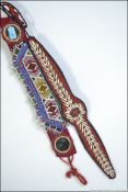 2 Afghan bead and shell worked work belts, one with oval inset mirror glass,