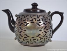 An early to mid 20th century ceramic teapot having a stunning Elkington Plate Co fret pierced cover.