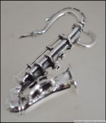 A silver miniature saxophone pendant musical instrument of decorative form. Stamped 925.