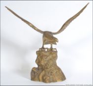 A 20th century cast brass ornamental Osprey Sea Eagle with wings at full span upon a naturalistic