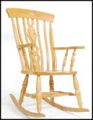 A 20th century beech and elm framed Windsor rocking chair, having a high, shaped, back,