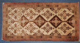 An early 20th century handwoven rug with central run of medallions of geometric form having stub