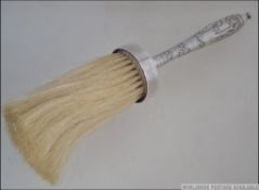 An Indian - Anglo Chinese silver table crumb brush cast with scenes of figures and landscape,