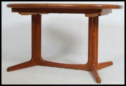 A compact vintage / retro danish extending teak wood dining table raised on splayed legs with