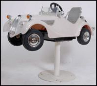 A contemporary barbers chair in the form of a car raised on pedestal.