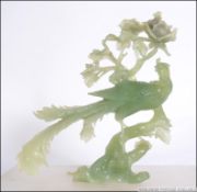 A Chinese green glass / stone jade coloured ornament in the form of an asiatic pheasant set to a