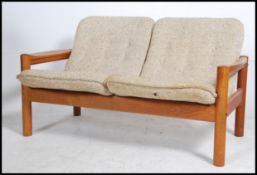 A retro 20th century Danish teak framed two seater sofa with drop oatmeal fabric seats by Domino.