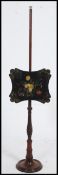 A Regency mahogany pole screen raised on a circular base with laquered chinoserie panel that