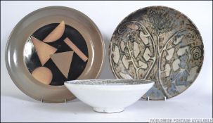 A group of three pieces of Studio pottery to include a two chargers and a bowl the chargers having