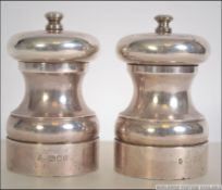 A pair of silver hallmarked pepper and salt cruet mills. London assay marks.