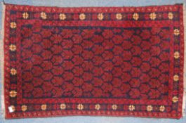 A 20th century Persian rug with unusual medallion design on red ground.