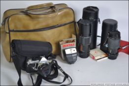 A vintage Pentax 35mm camera along with cased lenses, flash etc all within a carry bag.
