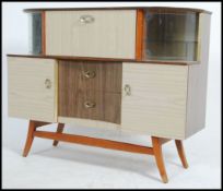A retro 1950's large melamine drinks cabinet / sideboard raised on tapered legs with sliding glass