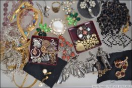 A box of vintage costume jewellery to include brooches, beaded necklaces,