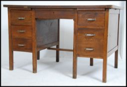 A vintage mid century Air Ministry style oak twin pedestal desk having thick flared top with