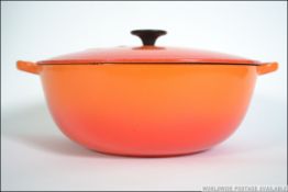 A large Le Creuset enameled cast iron lidded Soup / casserole Pot with, in a red finish.