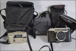 A collection of assorted vintage and contemporary cameras to include a Yashika and others.