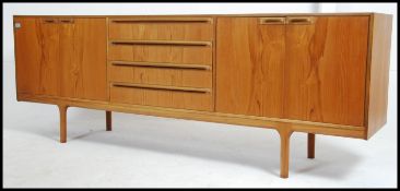 A good 1970's teak McIntosh sideboard of Danish influence being raised on tapering supports