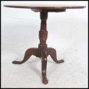 An early 19th century Georgian country oak tilt top circular occasional table - wine table raised