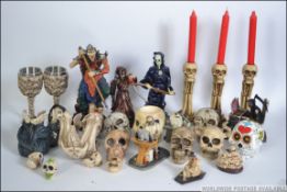 A collection of novelty skull items and figurines to include Death, bottle holders, candle sticks,