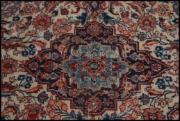 An early 20th century Persian style floor rug, red ground with blue borders.