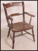 A Victorian beech and elm Oxford Windsor back back armchair having saddle seat and raised on turned