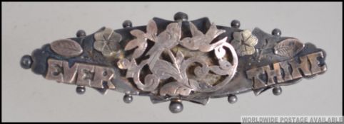 A silver hallmarked forget me not brooch with gold notation ' Ever Thine ' hallmarked for