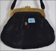 A black velvet ladies evening bag with gilt metal frame and clasp decorated with gold overlay in