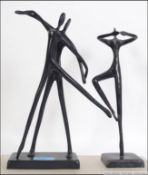 A pair of Art Deco style metal sculptures of dancing figures on square bases.