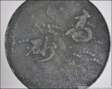 A 20th century Chinese / Japanese bronze hand mirror relief decorated with character marks to the