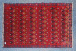 A 20th century Persian rug with unusual medallion design on red ground.