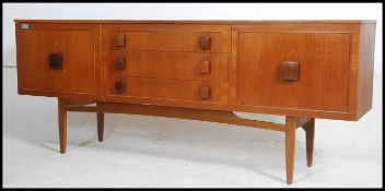 A retro 20th century teak effect sideboard having three drawers to the centre flanked on both sides