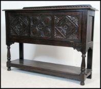 A good mid century Jacobean revival solid oak carved wine cooler cabinet being raised on turned