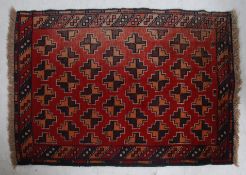 A 20th century Persian Bokhara rug with unusual multiple medallion design on red ground having