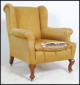 An Edwardian Howard style wingback chesterfield armchair with scrolled rolled arms and back.