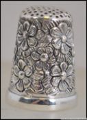 A silver 925 thimble being cast in relief with rococo scrollwork. Weight 11.