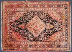 A 20th century Persian rug with red ground having central medallion with black borders having