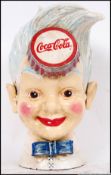 A vintage style, 20th century cast iron Coca Cola money bank of a young boys head.