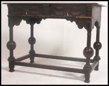 A 19th century Jacobean revival writing table - side table desk being raised on cup and cover legs