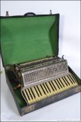 A cased Alvari accordian dating to the 1930's with marbled grey and black body complete with the