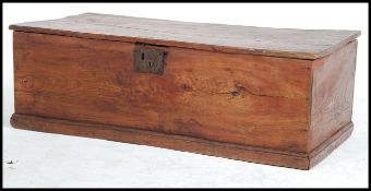 An 18th century carved elm / oak blanket box - chest coffer having a plinth base with hinged top