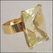 A 14ct gold oversized ladies dress ring having a large citrine coloured cushion cut glass stone.