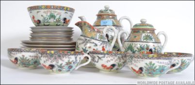 An early 20th century Chinese Cantonese tea service decorated with scenes of fighting cocks,