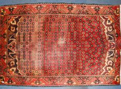 A 20th century Persian rug with unusual medallion design on red ground having stunning angular