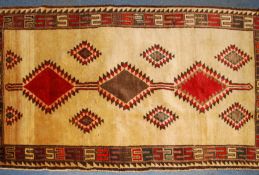 A handwoven beige Persian Rug of Iranian origin with central run of medallions having black ground