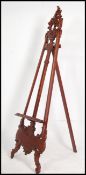 A 20th century Hardwood full height easel - artists stand with rococo form together with a framed