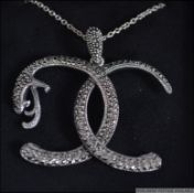 A silver 925 ladies Double C ' Chanel ' cobra necklace pendant set to a chain.