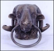 A cast iron door knocker of a Rams head. 21cm long.