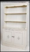A 20th century painted pine shabby chic welsh dresser being raised on a plinth base with cupboards